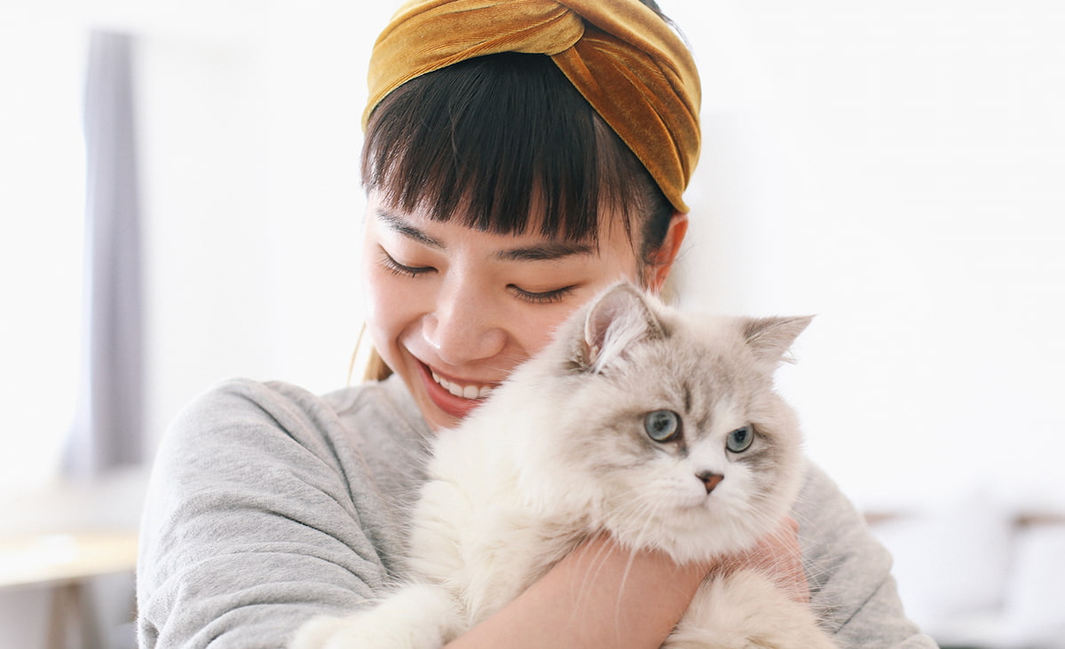 Female pet owner smiling and holding cat - Zoetis