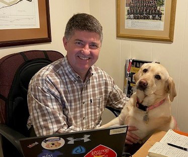 Zoetis veterinarian posing with dog in office - Zoetis