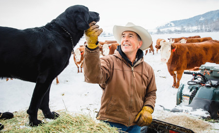 Producer petting dog, beef cattle in the background - Zoetis