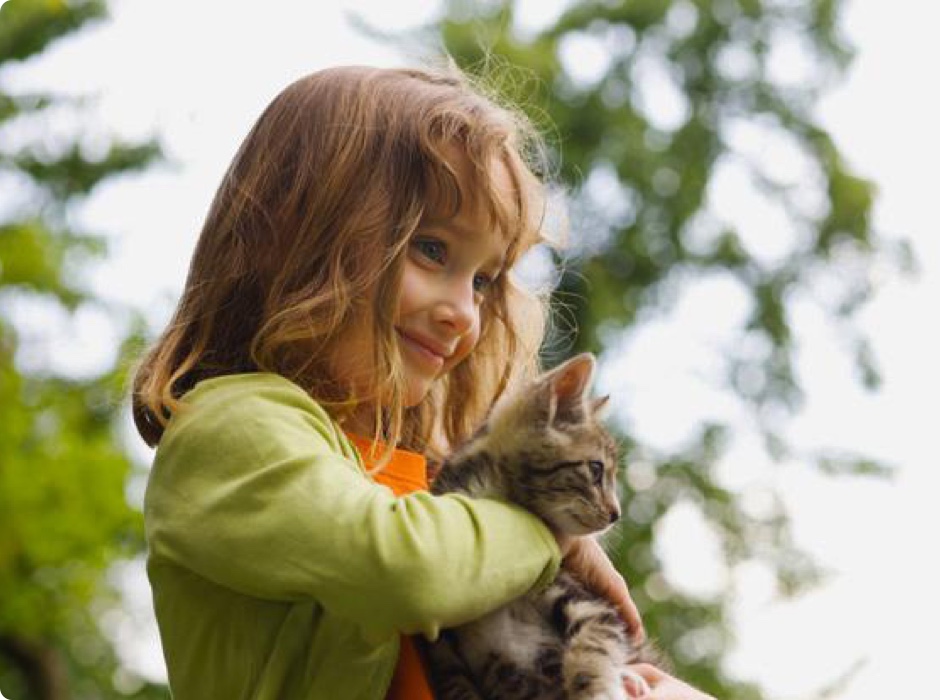 Young girl carrying a cat outside - Zoetis